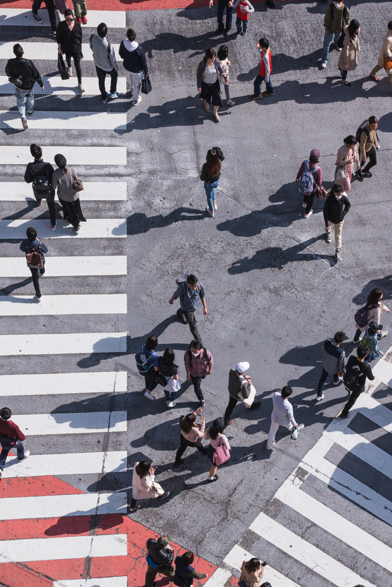 Crowd of people moving about a crosswalk.